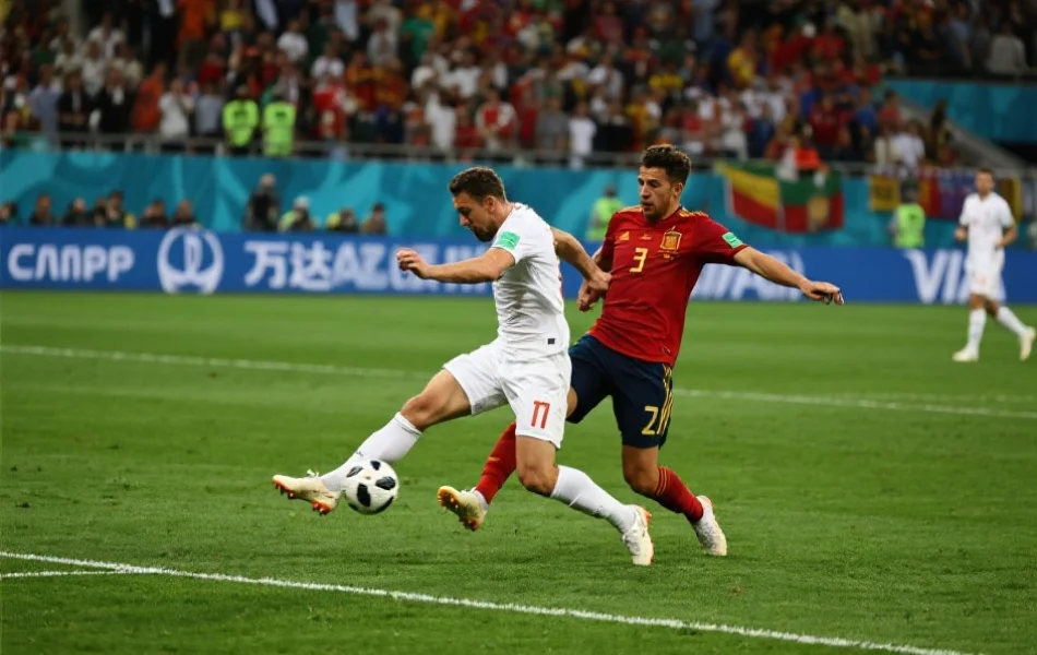 足球运动员在决赛现场激烈拼抢，球场草地清晰可见，现场观众聚焦比赛